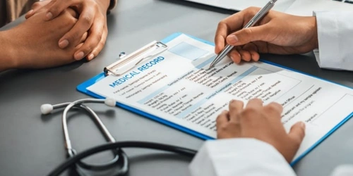 Doctor writing on a clipboard in an office, representing time spent on clinical documentation