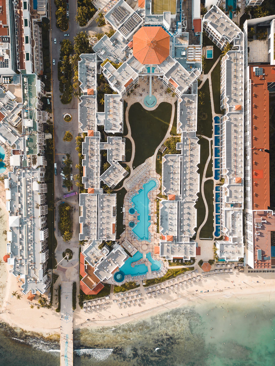 Aerial view of a beach resort with a pool, representing resort management technology