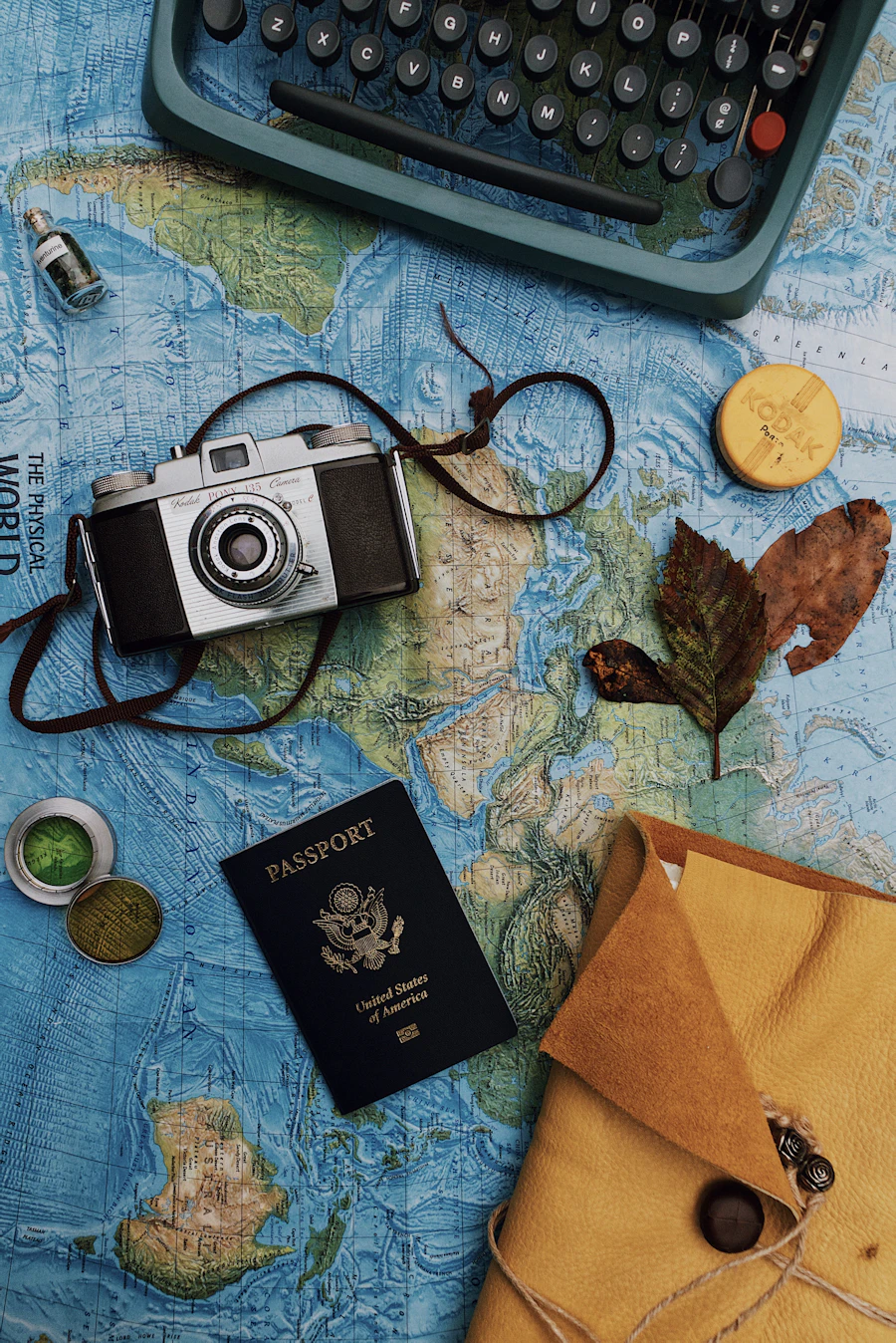 Flat lay of camera, laptop and passport, representing travel agency booking technology